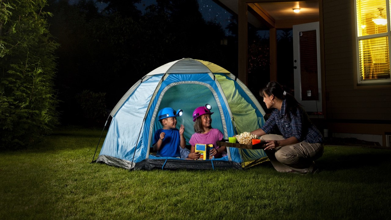 image of a family camping in a tent in the backyard at night - 3 bedroom apartments in lafayette la