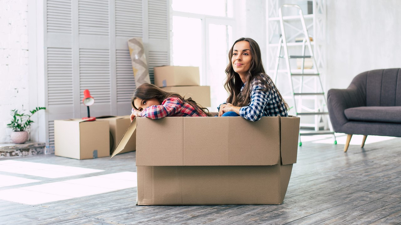 image of a woman and her daughter sitting inside a moving box in an fairly empty room - 1 and 2 bedroom apartments in lafayette la