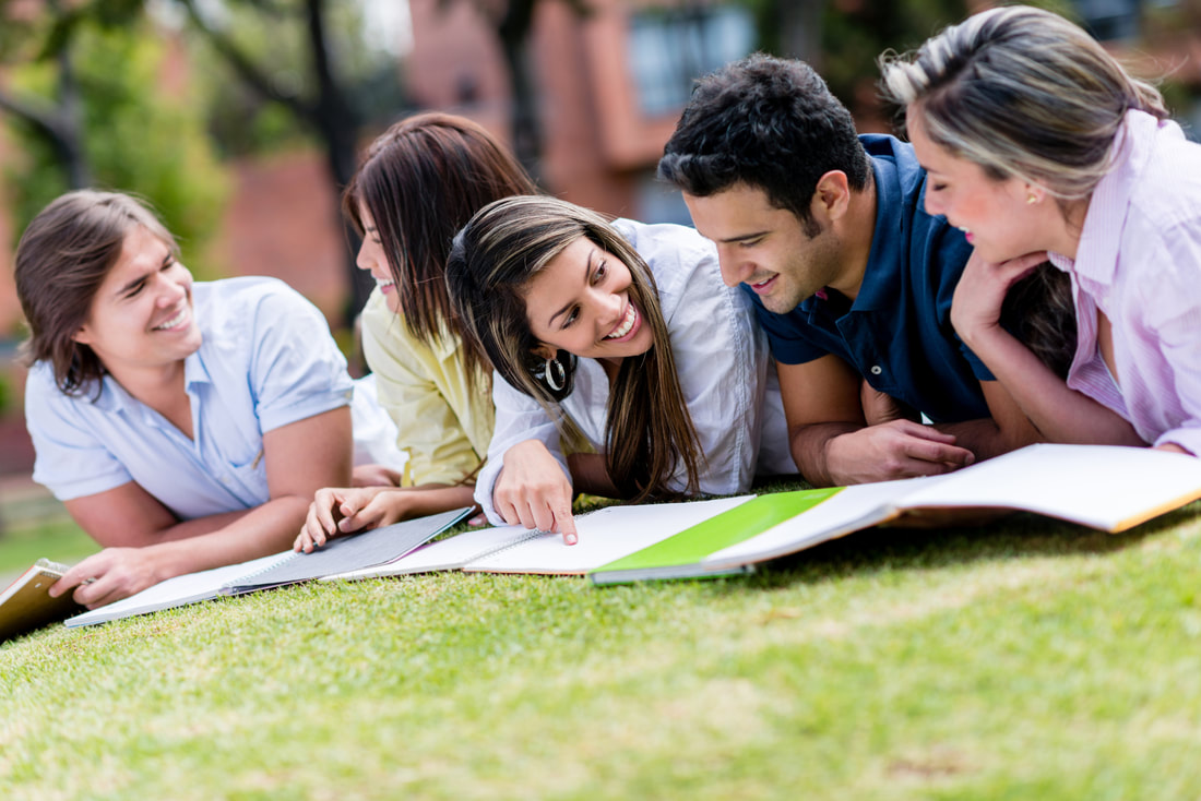 College students studying on the grass on campus - college apartments - lafayette la 